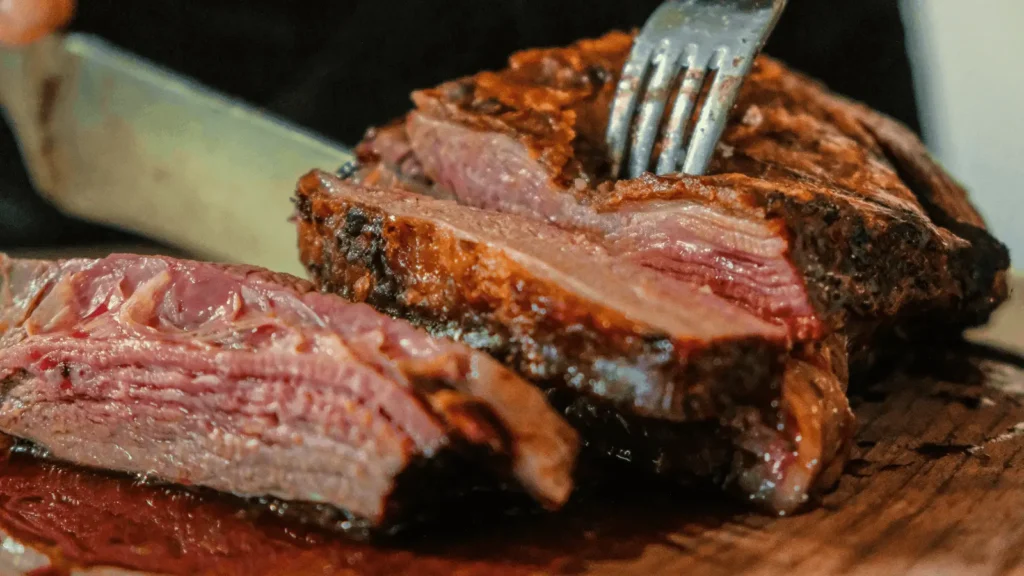 Close-up of juicy smoked beef brisket pastrami sliced on a cutting board showing tender texture and smoke ring