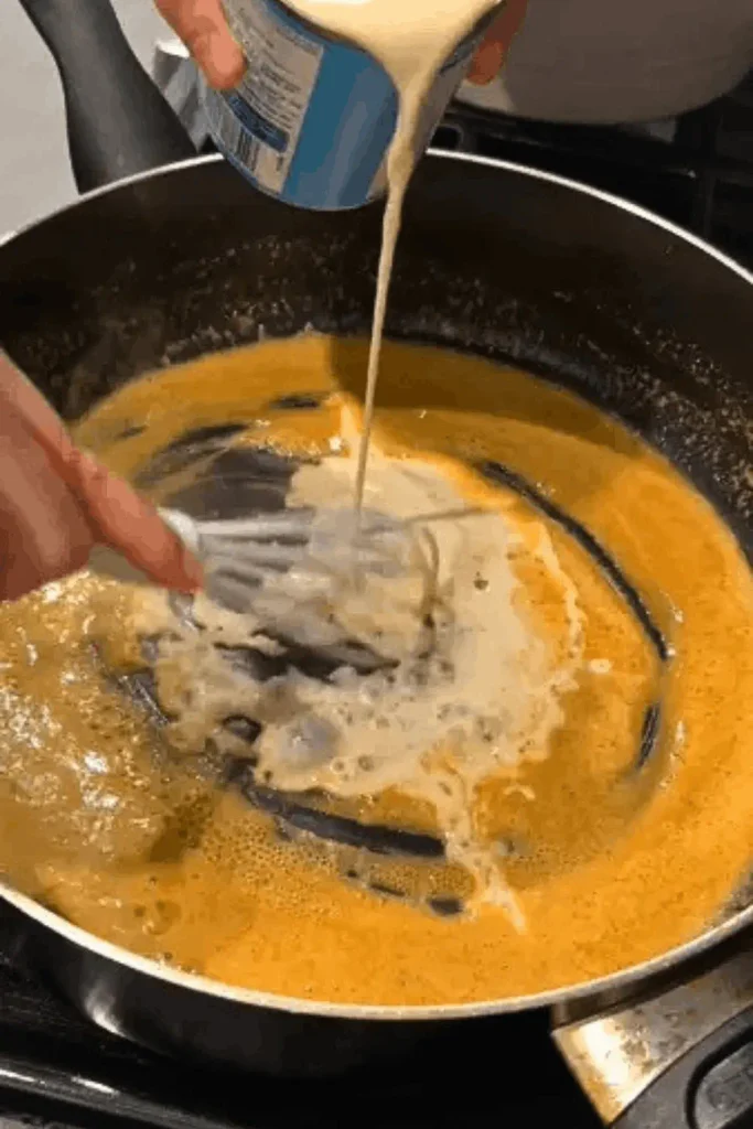 Milk being whisked into a buttery roux for Paula Deen crockpot mac and cheese sauce